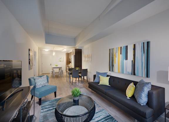 A living room with a black couch and a blue chair.