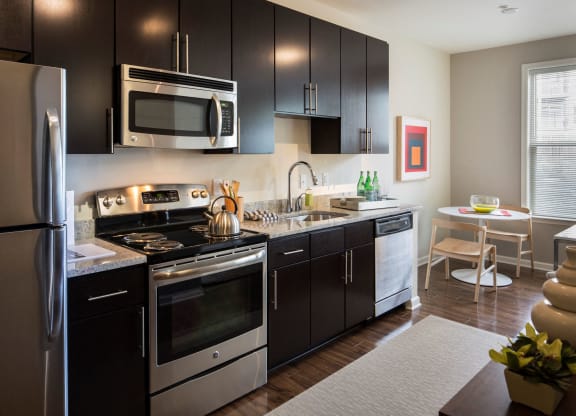 A kitchen with brown cabinets and steel appliances.