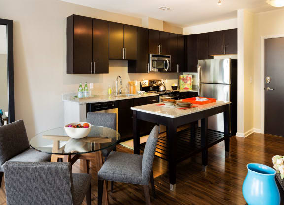 A kitchen with an island and table in front.
