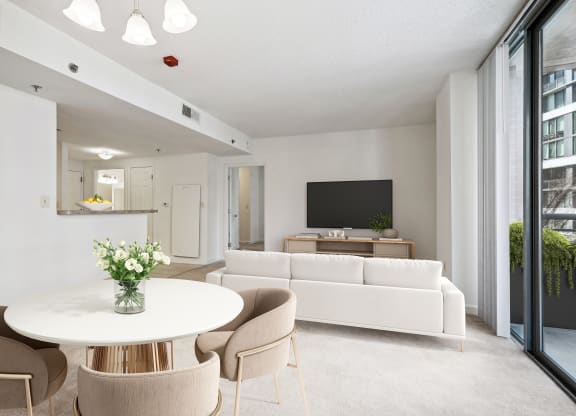 a living room with white furniture and a white table and chairs
