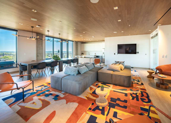 a living room with a gray couch and a table with chairs