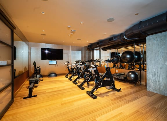 a gym with weights and a tv on the wall