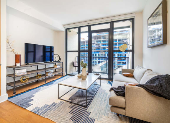 a living room with a couch and a tv and a large window