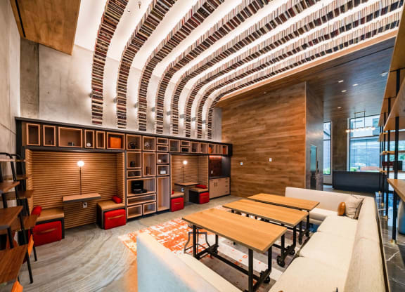 a large living room with tables and a kitchen in a lobby