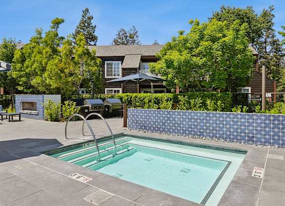 Outdoor hot tub at Grove Apartments with surrounding seating and greenery