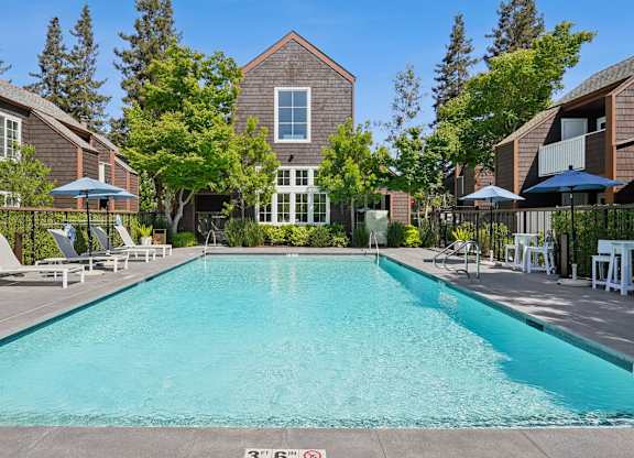 Outdoor swimming pool at Grove Apartments with lounge chairs and landscaped courtyard.