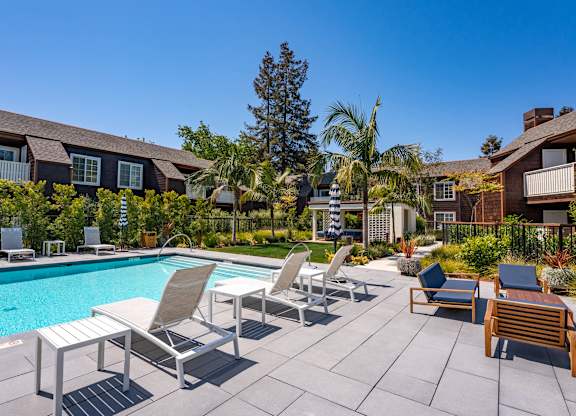 Pool deck at Grove Apartments with lounge chairs and open sunlit space