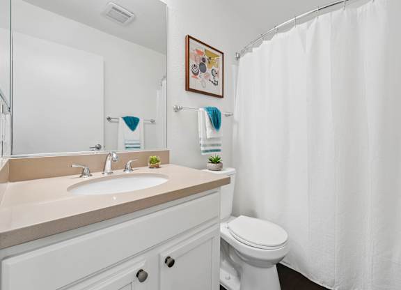 Bathroom at Grove Apartments with vanity storage, full-size tub, and modern fixtures.