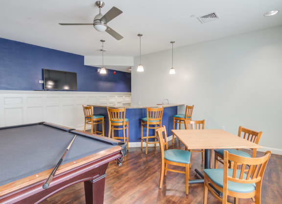 a room with a pool table and a table with chairs