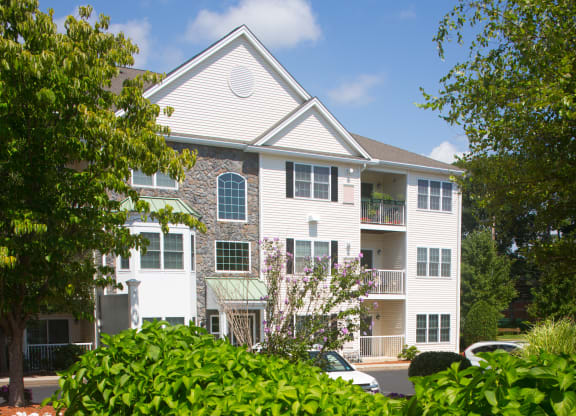 a white apartment building with a car parked in front of it
