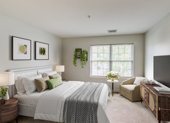 a bedroom with a bed and a chair and a television