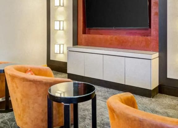 a living room with a tv and chairs and a table