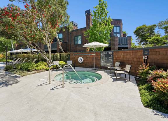 Outdoor hot tub with lounge seating and landscaped surroundings at Indian Creek Apartments.
