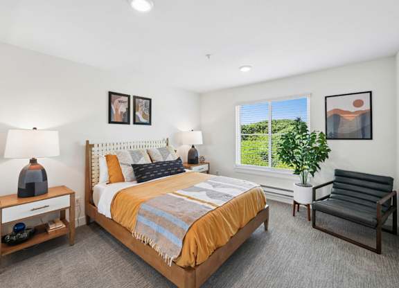 Bedroom with neutral decor, large window, and modern furnishings.