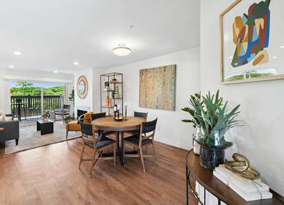 Dining area with round table, modern decor, and open living room layout.