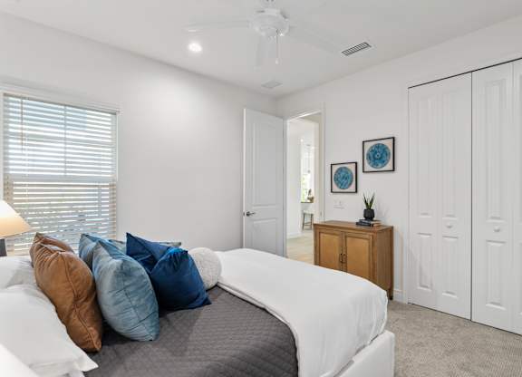 A bedroom with a bed, pillows, and a ceiling fan at Marisol in Lakewood Ranch, FL