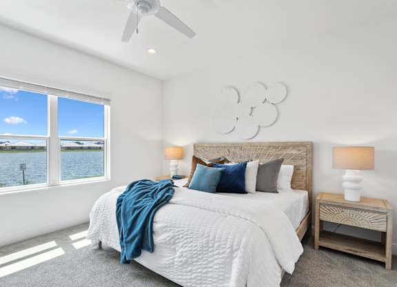 A bedroom with a large bed and a view of the water at Marisol in Lakewood Ranch, FL