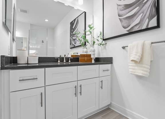 A bathroom with white cabinets and a large mirror at Marisol in Lakewood Ranch, FL