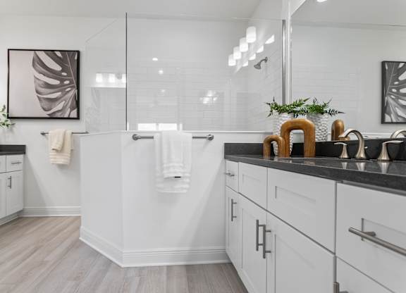 A bathroom with a white tub and a plant on the counter at Marisol in Lakewood Ranch, FL