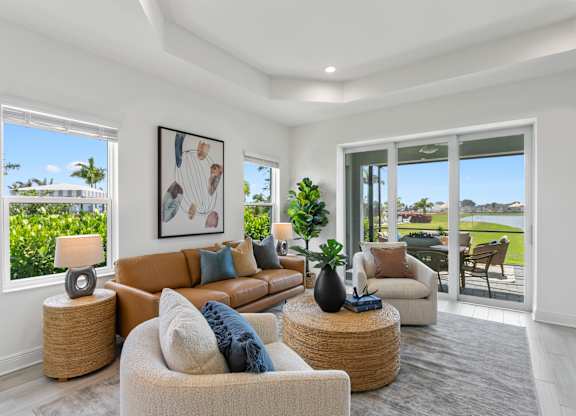 A well-lit living room with a large window and a view of a green lawn at Marisol in Lakewood Ranch, FL