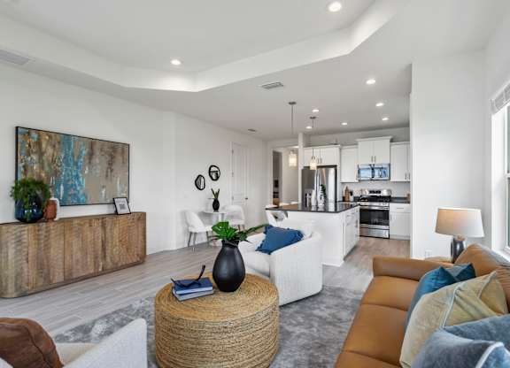 A modern living room with a white sofa and a wooden coffee table at Marisol in Lakewood Ranch, FL