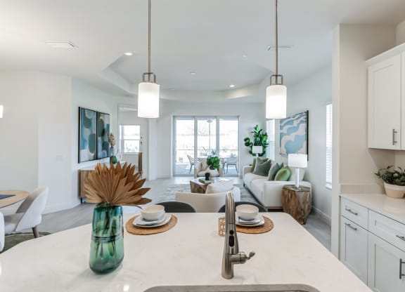 an open kitchen and living room with white cabinets and a white counter top at Marisol, Bradenton Florida