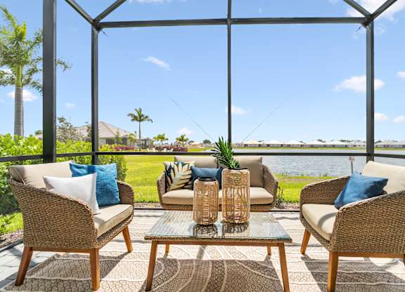 A patio with a table and chairs with a view of the water at Marisol in Lakewood Ranch, FL