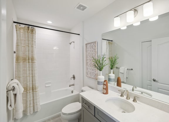 Upstairs bathroom with tub and spacious vanity in 3 bedroom rental home
