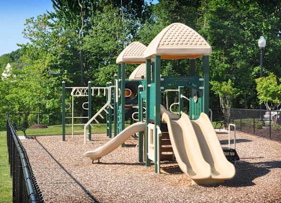 A playground with a green slide and a yellow slide.