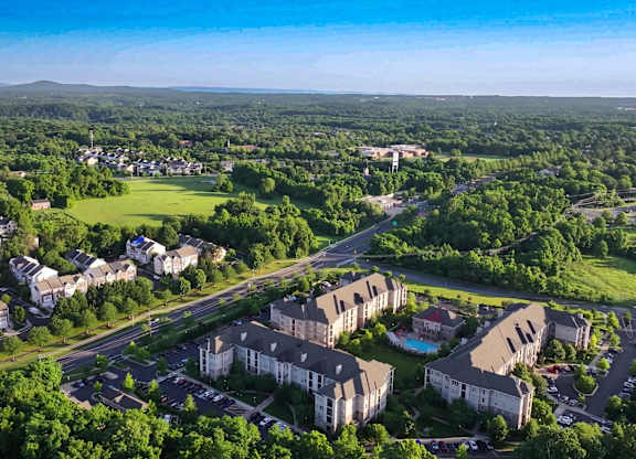 A bird's eye view of a residential area with houses and a swimming pool.