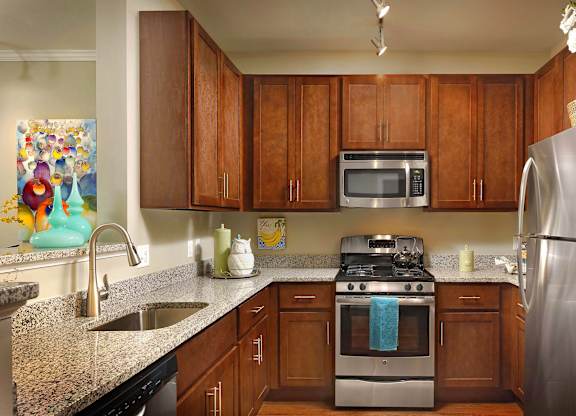A kitchen with brown cabinets and a stainless steel refrigerator.