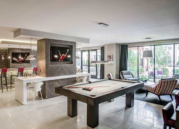 A room with a pool table and a television.