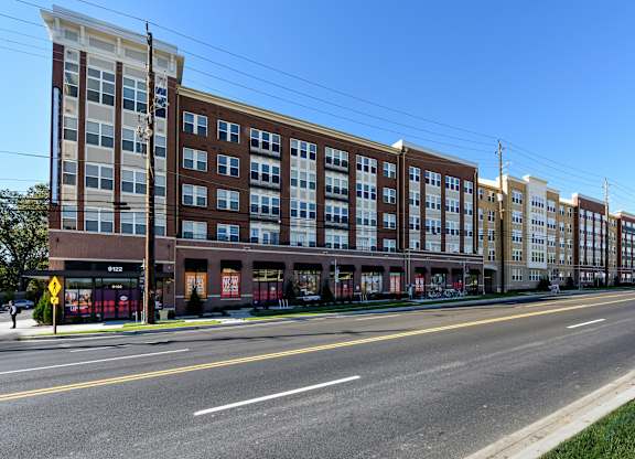 A street view of a multi-story building with a clear blue sky above.
