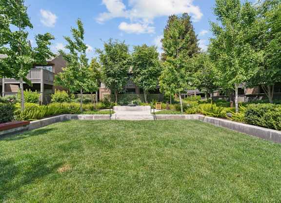 Courtyard with decorative fountain, benches, and landscaped greenery