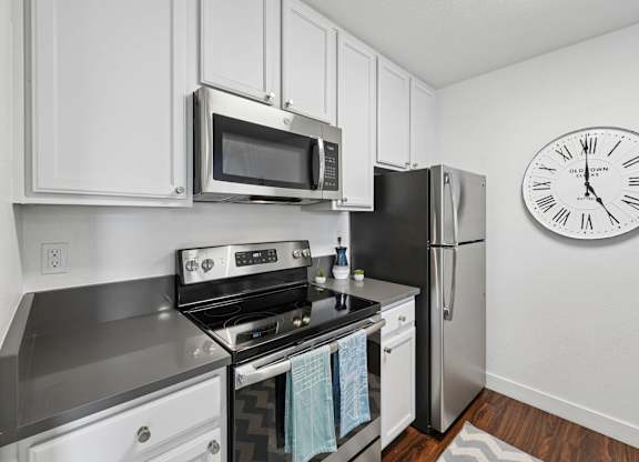 Modern kitchen at Old Orchard Apartments with stainless steel appliances and white cabinetry.