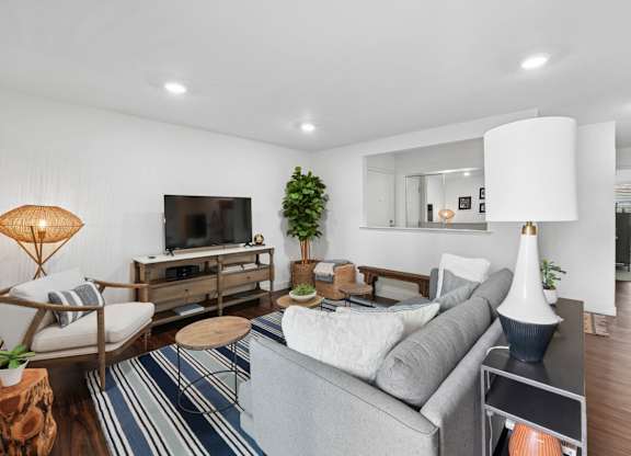 Living room with sofa, TV, coffee tables, and sliding glass door leading to patio