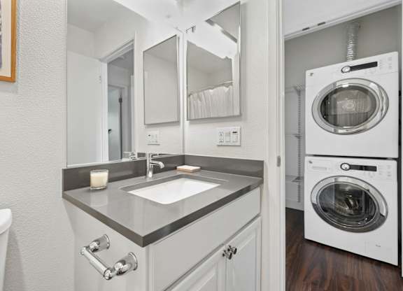 Stacked washer and dryer unit in dedicated laundry space at Old Orchard Apartments