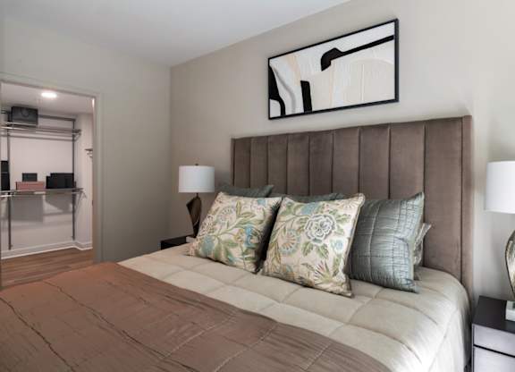A bedroom with a large bed and a painting above it.
