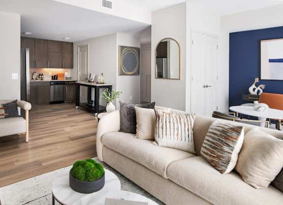A living room with a couch, a coffee table, and a potted plant.