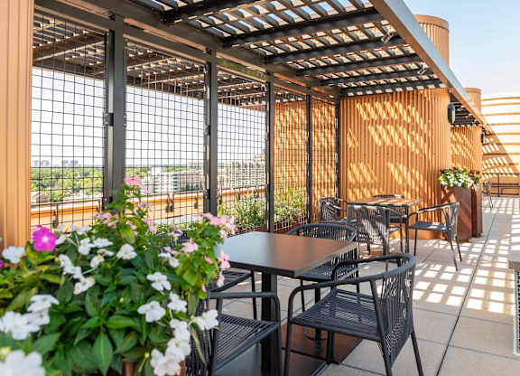 an outdoor patio with tables and chairs and a pergola