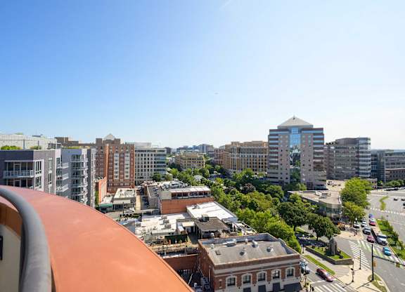a view of the city from the balcony of a building on a sunny day