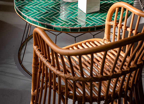 A table with a plant on it and two chairs.