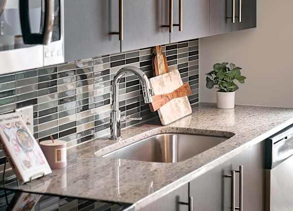 A modern kitchen with a stainless steel oven and a granite countertop.