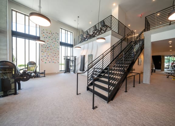 the lobby of a gym with a spiral staircase