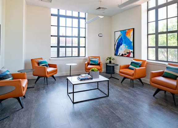 a living room with orange chairs and a coffee table