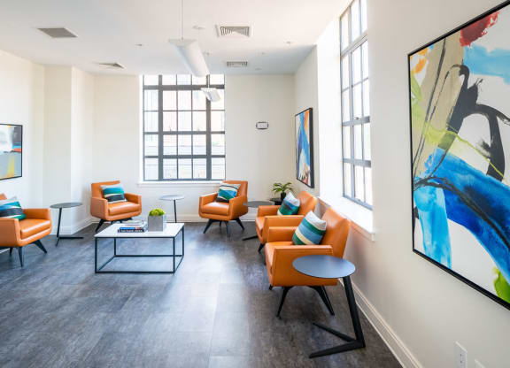 a living room with orange chairs and a table