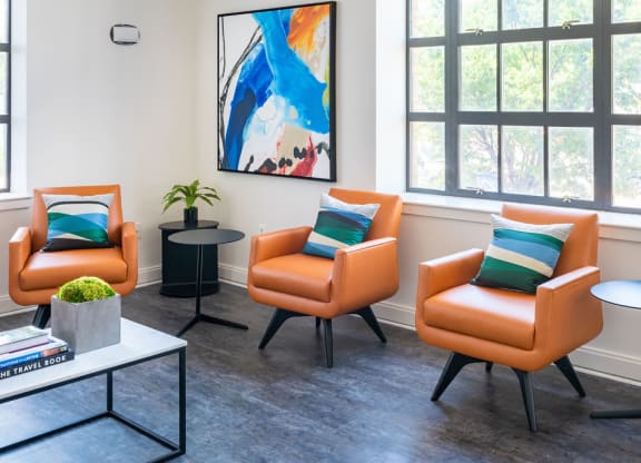 a living room with orange chairs and a table