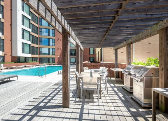 a patio with tables and chairs and a swimming pool
