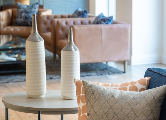 a living room with a couch and a table with vases on it