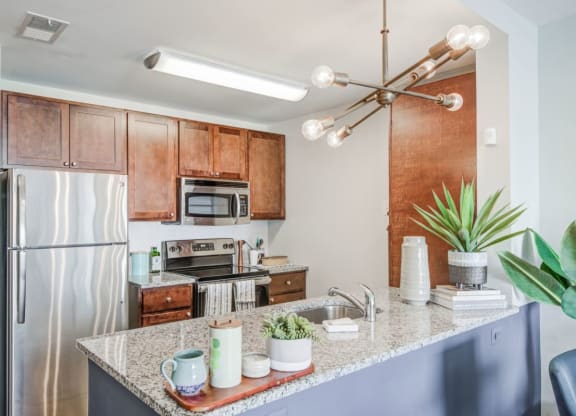a kitchen with a granite counter top and a stainless steel refrigerator